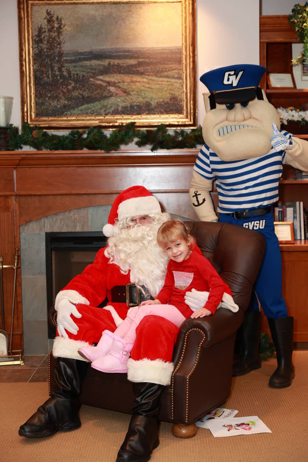 A daughter of an alum sitting with Santa & Louie.